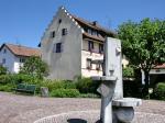 Das Gasthaus Adler in Oberlauchringen. Im Vordergrund sieht man die Brunnenskulptur auf dem Platz gegenüber