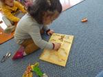 kleines Mädchen beim Spielen mit hölzernen Tierfiguren