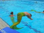eine Meerjungfrau mit grüner Flosse beim Sprung ins kühle Nass