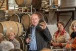 Bürgermeister Schäuble hält zum Abschluss eine Rede beim Besuch des Weingutes Clauß. Im Hintergrund stehen mehrere hölzerne Weinfässer sowie andere Winzerutensilien